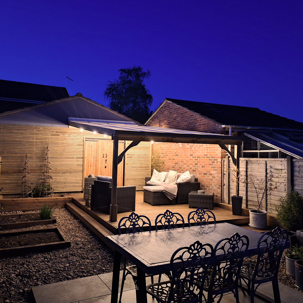Outdoor patio and gazebo area with furniture and lighting at night