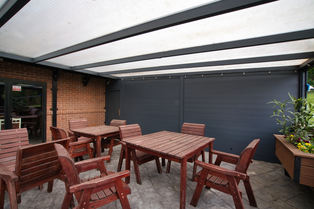 Outdoor patio area with wooden tables and chairs