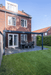 Outdoor patio area with a Veranda attached to a brick house.