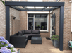 Outdoor patio with a Duponti Giallo, sectional sofa, and potted plants.