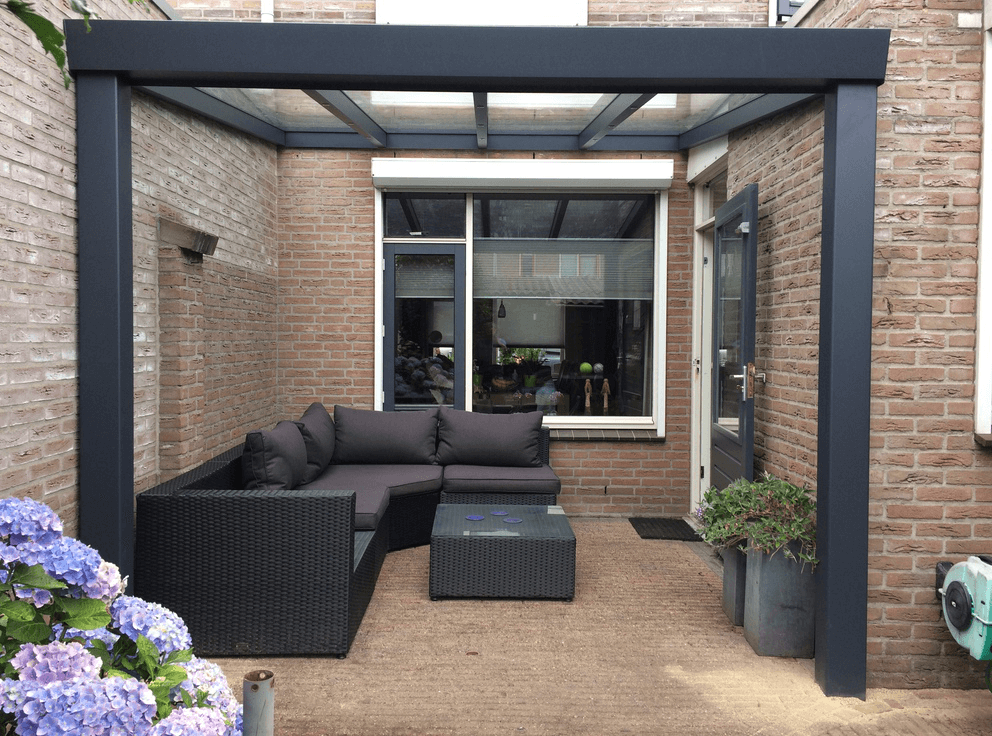 Outdoor patio with a Duponti Giallo, sectional sofa, and potted plants.