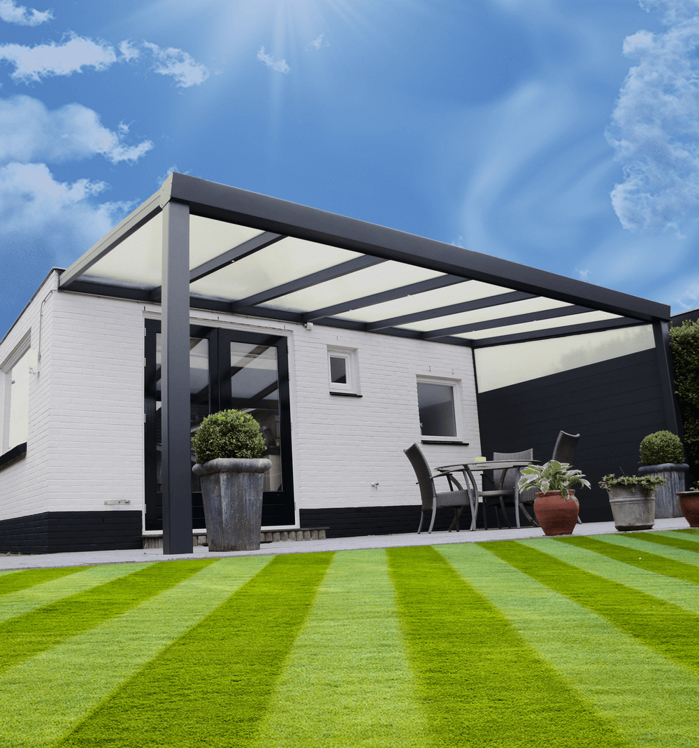 Patio cover with white roof and black frame in a garden setting with a clear blue sky.