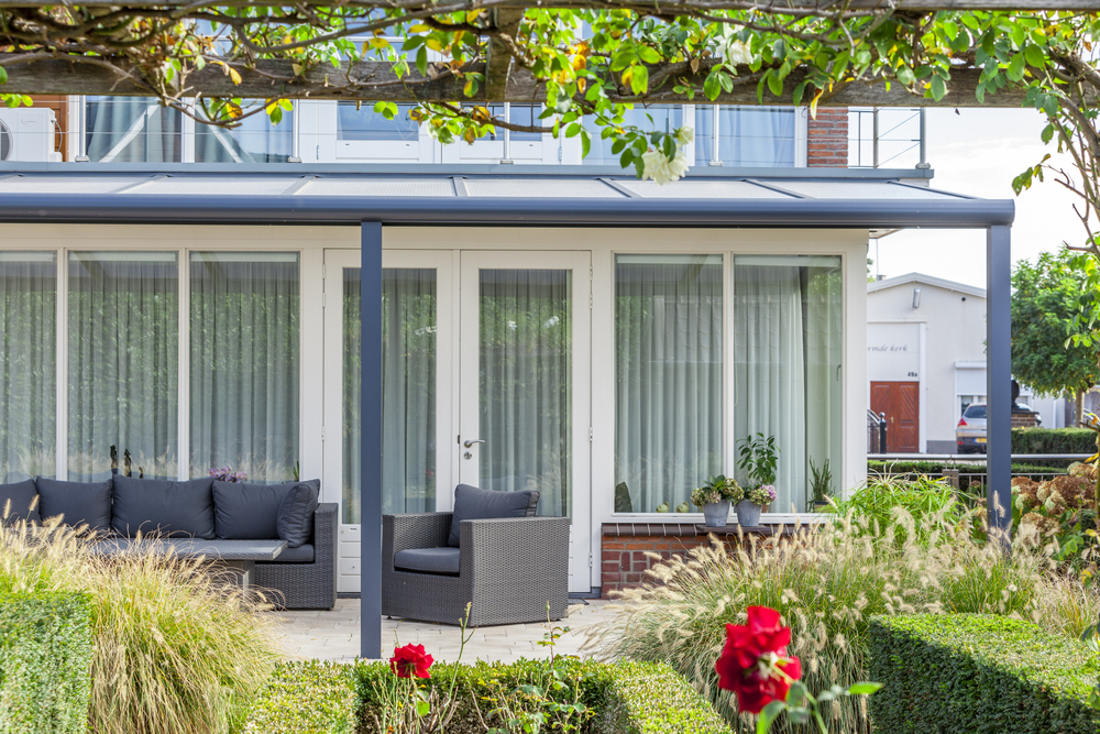 Modern house exterior with patio furniture and garden