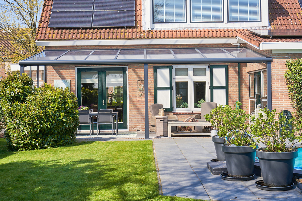 House with solar panels on the roof, garden, and patio area.