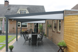 Patio area with pergola, outdoor furniture, and plants in a residential setting.