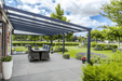 Outdoor patio with pergola, dining table, and garden view