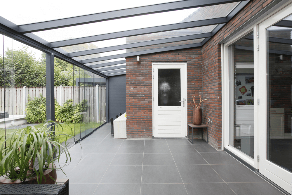 Modern patio area with glass roof and brick wall