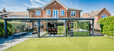 Modern house with a Deponti Pigato extension and outdoor furniture on a sunny day.