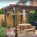 Wooden outdoor patio set with pergola, table, and benches in a garden setting.