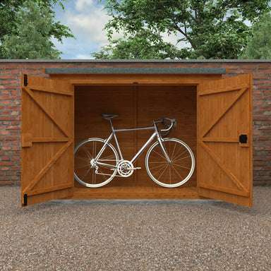 Wooden bike shed with a bicycle inside, set against a brick wall and green trees.