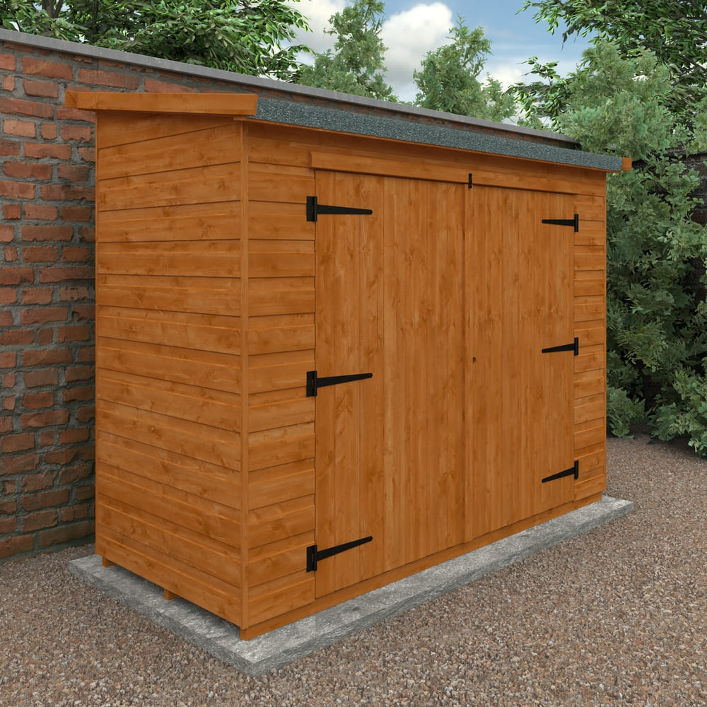 Wooden shed attached to a brick wall with greenery in the background