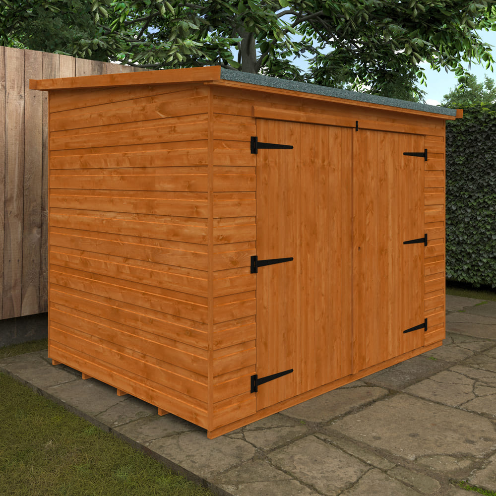 Wooden shed with a green roof on a stone patio
