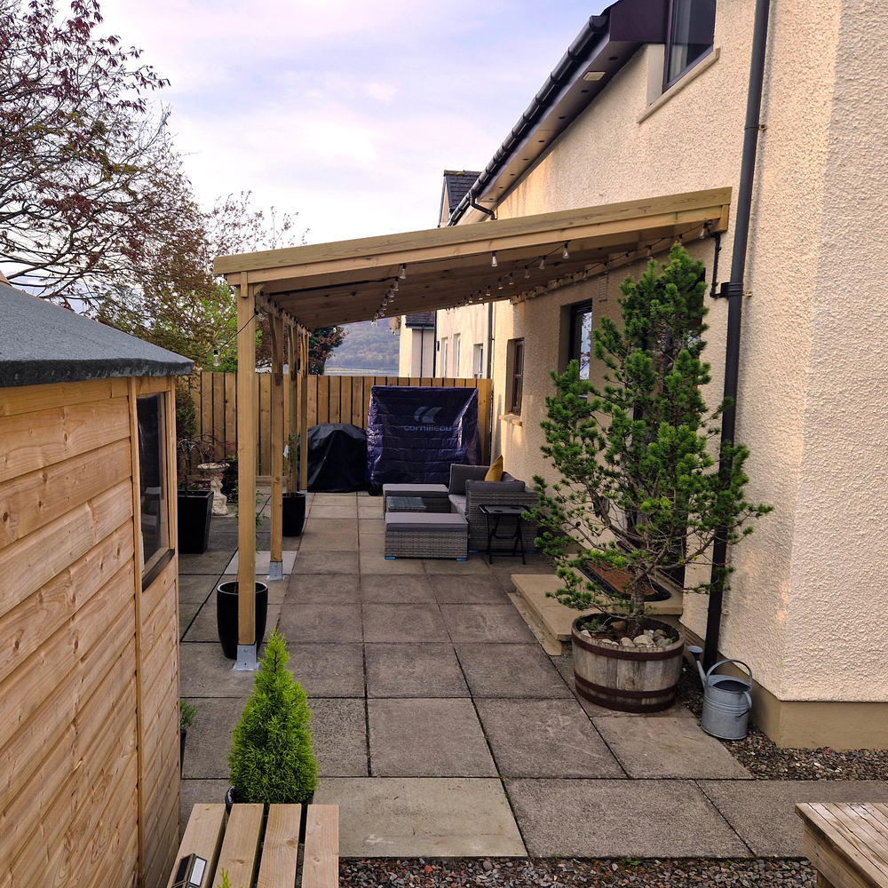Backyard patio with wooden gazebo, outdoor furniture, and plants.