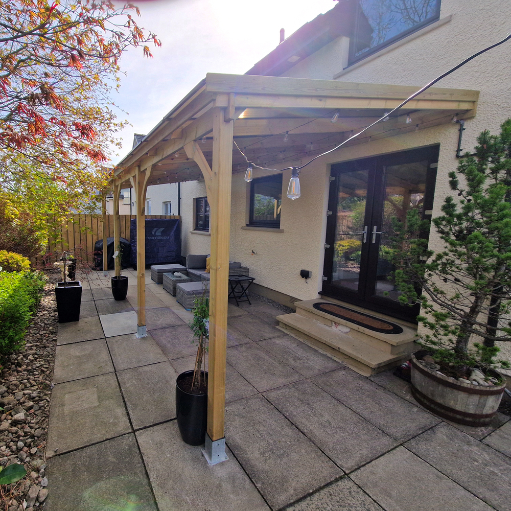 Backyard patio with wooden gazebo, outdoor furniture, and plants.