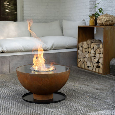 HEAT Gystad fire pit with flames on a base plate on a patio
