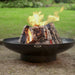 HEAT Classic black fire bowl with logs burning on a gravel garden floor