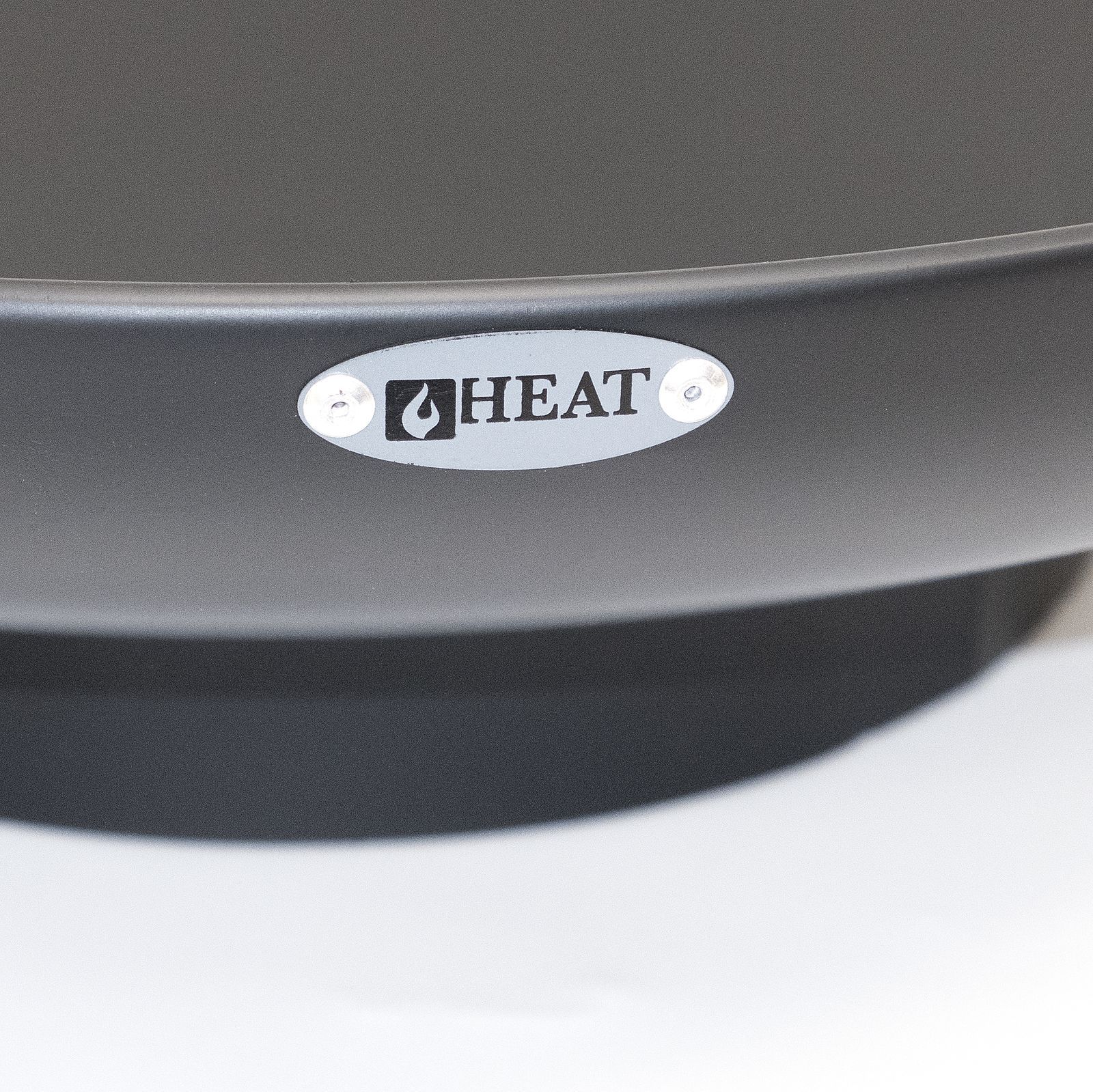 Close-up of the HEAT badge on the rim of a Classic black fire bowl