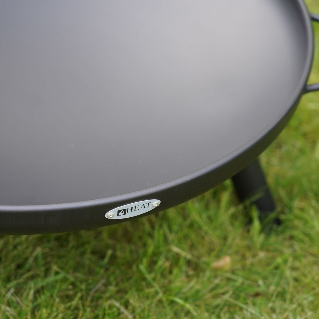 Close-up of a HEAT Classic black fire bowl rim and leg on grass