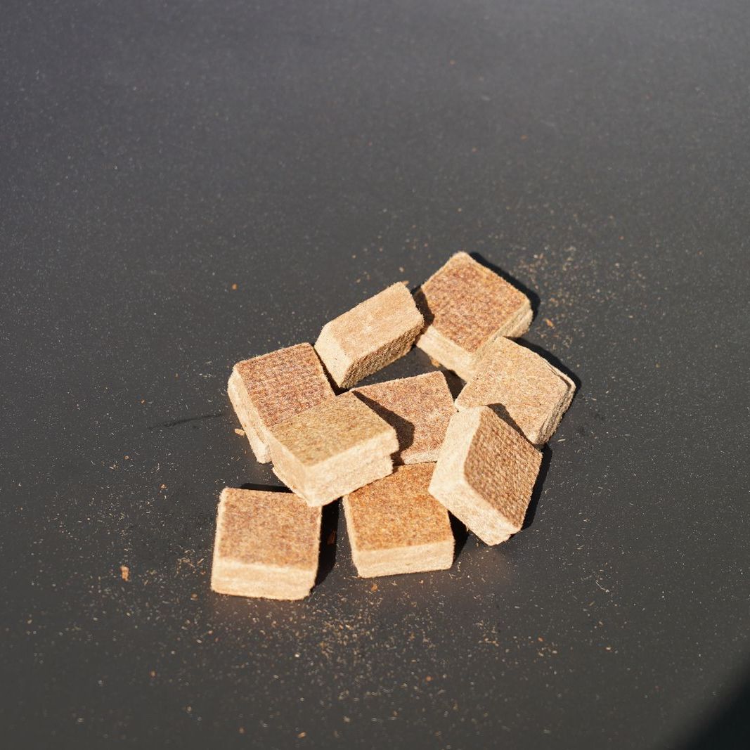 HEAT wood fibre firelighter cubes on a dark surface