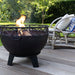 HEAT Boble fire bowl burning on decking beside rattan chairs