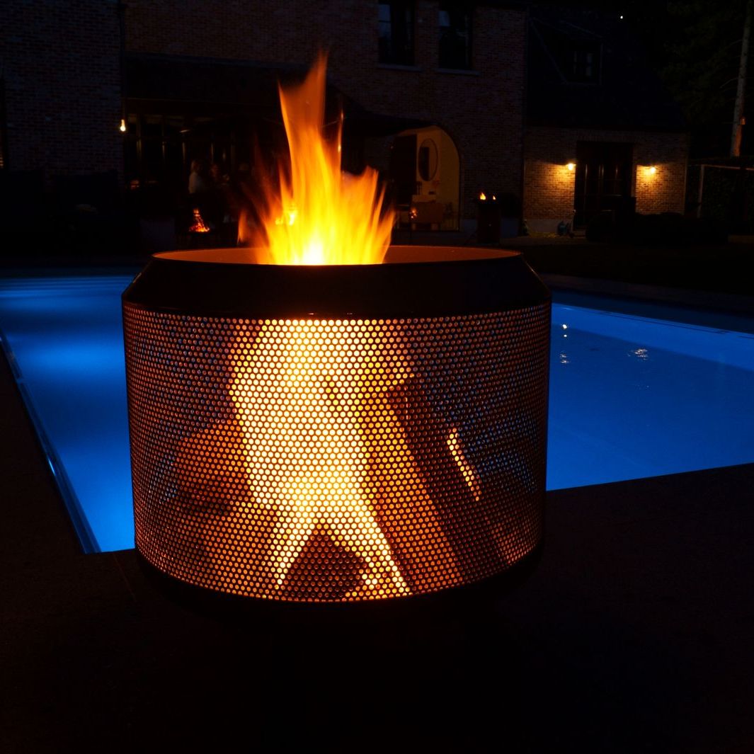 HEAT Fire Drum glowing at night beside a lit pool
