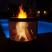 HEAT Fire Drum glowing at night beside a lit pool