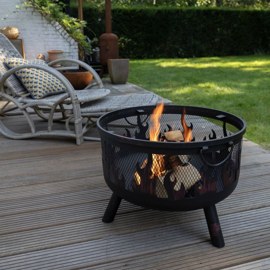 HEAT Hornset fire pit burning on decking beside a rattan chair