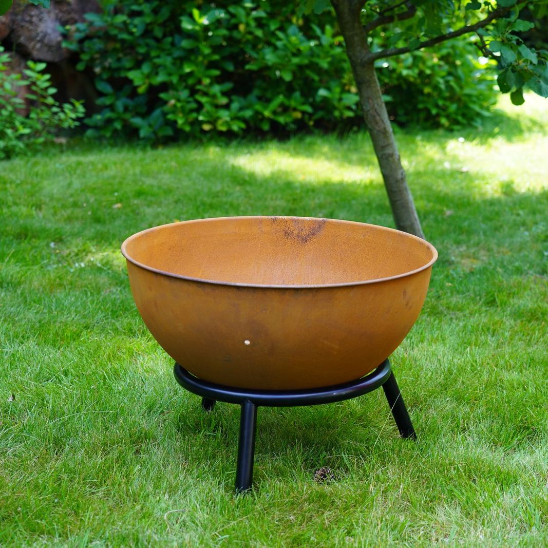 HEAT Kappa rust fire pit standing on a lawn under a tree