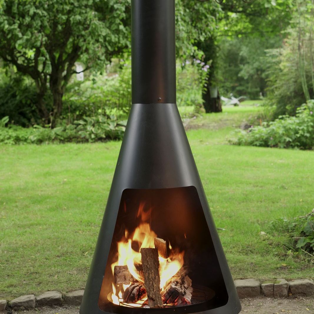 HEAT La Luz chiminea with a log fire glowing on a garden lawn