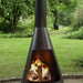 HEAT La Luz chiminea with a log fire glowing on a garden lawn