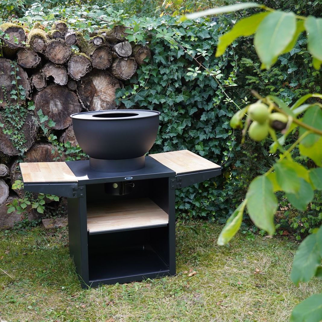 HEAT Kjok black outdoor kitchen with work benches open in a garden