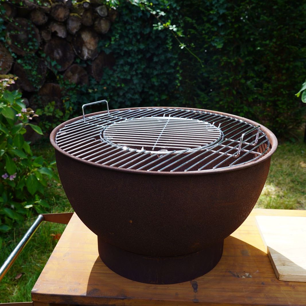 HEAT Trolle fire bowl with grill fitted on the griddle, garden view