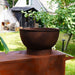 HEAT Trolle rust fire bowl and unit in a garden, close view