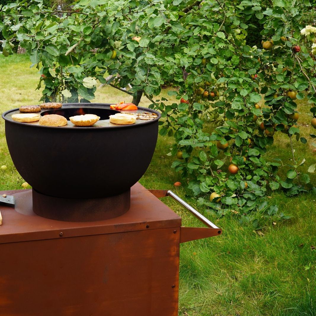 Food cooking on the HEAT Trolle griddle in a garden