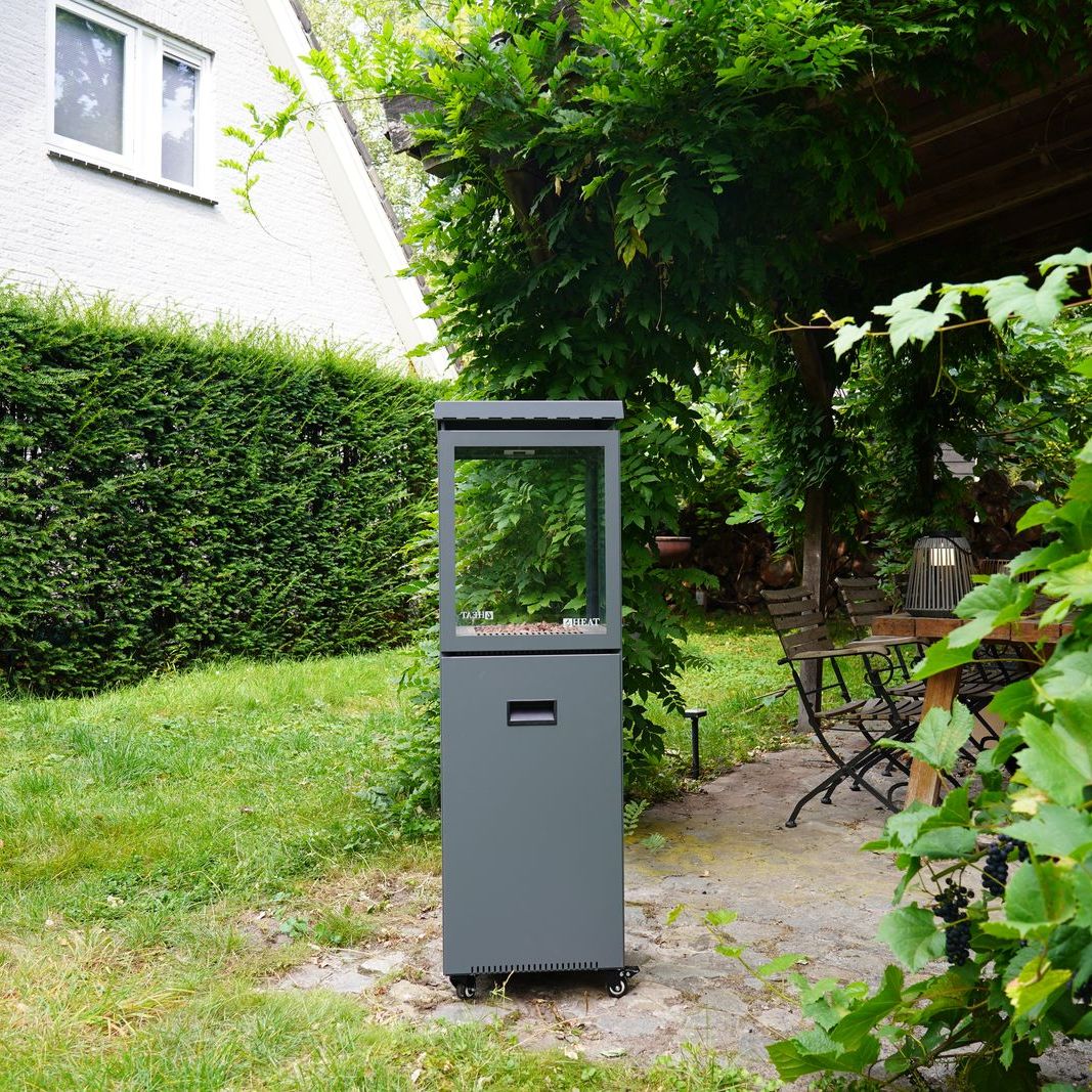 HEAT Utevarme patio heater in the corner of a lawned garden