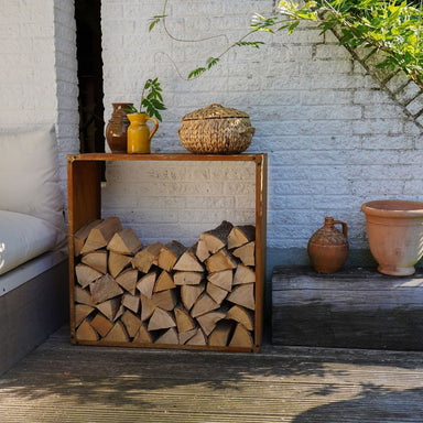 HEAT Dokka log store stacked with firewood by a white wall