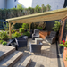 Outdoor patio area with wooden gazebo, chairs, and plants