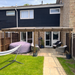 Backyard with patio furniture, gazebo, and garden hose storage.