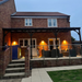 Brick house with a wooden veranda and outdoor seating area.