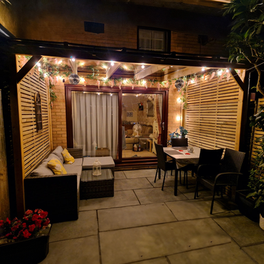 Outdoor patio area with seating and string lights at night